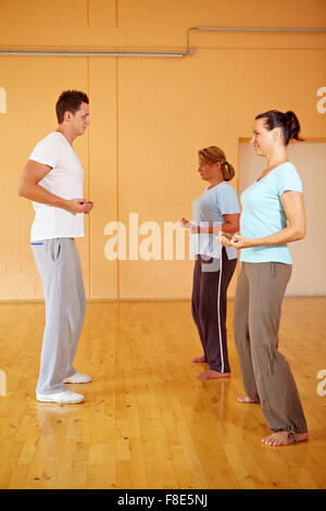 Zwei Frauen teilen einen personal Trainer in einem Fitnessstudio Stockfoto