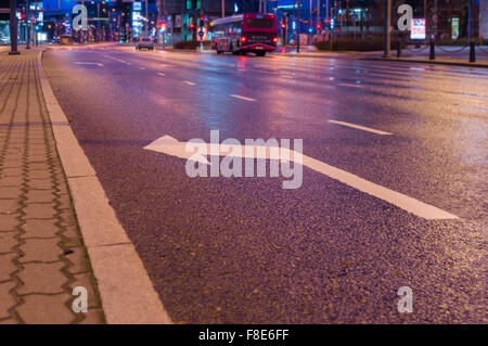 Biegen Sie links Zeichen markieren auf Asphalt, Nacht Stadtverkehr auf Hintergrund Stockfoto