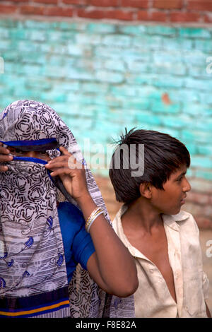 Unbekannte Frau Hidding ihr Gesicht mit ihrem Sohn in Indien Stockfoto