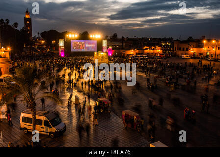 Nachtschwärmer versammeln sich, dass das große Kino-Bildschirm in der Djemaa el-Fna in Marrakesch, Marokko Stockfoto