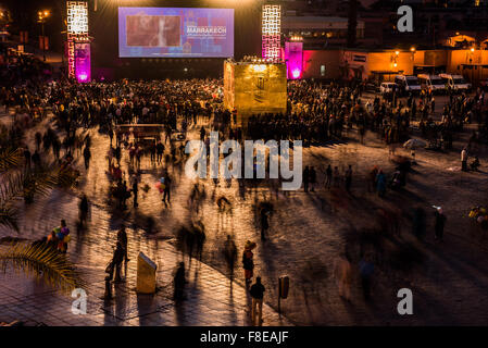 Nachtschwärmer versammeln sich, dass das große Kino-Bildschirm in der Djemaa el-Fna in Marrakesch, Marokko Stockfoto