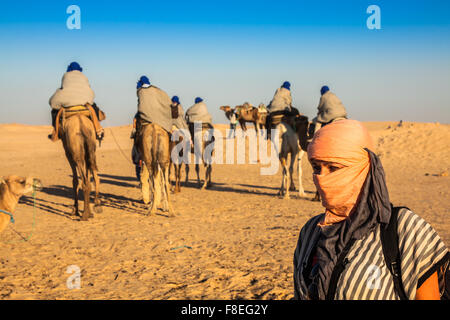 Beduinen führenden Touristen auf Kamelen auf kurze Rundfahrt um den Anfang so genannte Türen von Sahara Wüste, Douz, Tunesien Stockfoto