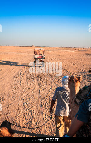 Beduinen führenden Touristen auf Kamelen auf kurze Rundfahrt um den Anfang so genannte Türen von Sahara Wüste, Douz, Tunesien Stockfoto