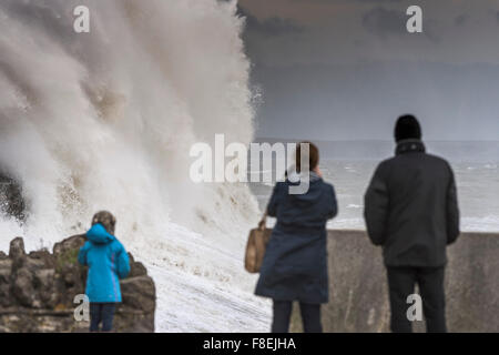 Menschen beobachten Sie, wie riesige Wellen brechen über das Kai und das Meer in Porthcawl, South.Wales. Stockfoto