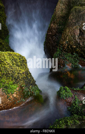 Abstraktes Bild von Wasser zwischen Felsen in einem Moor-Strom fließt. Aufgenommen in North Derbyshire, England. Stockfoto