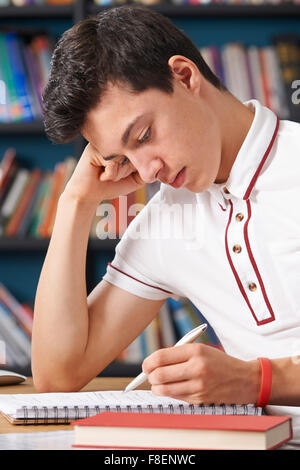 Männliche Schüler arbeiten In Bibliothek satt Stockfoto