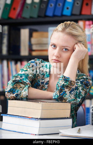 Teenager-Studentin In Bibliothek satt Stockfoto