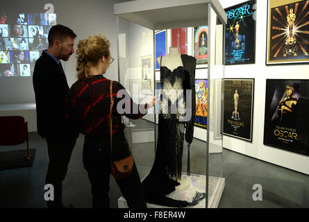 Besucher betrachten ein Kleid getragen durch die US-Sängerin Cher bei der Oscarverleihung 1988 in der Ausstellung "Bester Schauspielerin - Oscars", "Rollen" und "Bilder" in Berlin, Deutschland, 9. Dezember 2015. Die Ausstellung ist vom 10. Dezember 2015 bis 1. Mai 2016 in der Deutschen Kinemathek sehen. Foto: BRITTA PEDERSEN/dpa Stockfoto