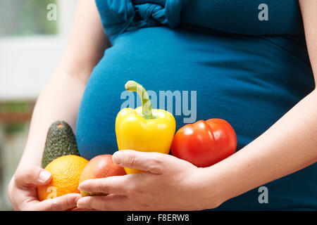 Schwangere Frau mit Obst und Gemüse hautnah Stockfoto