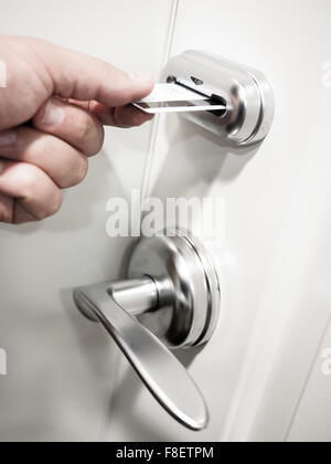 Hotel Zimmer exzentrische Türschloss mit die Hand einer Person einfügen Magnetstreifen Keycard um die Tür zu entriegeln Stockfoto