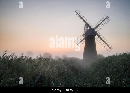 Windmühle in atemberaubender Landschaft an schönen Sommer Sonnenaufgang Stockfoto