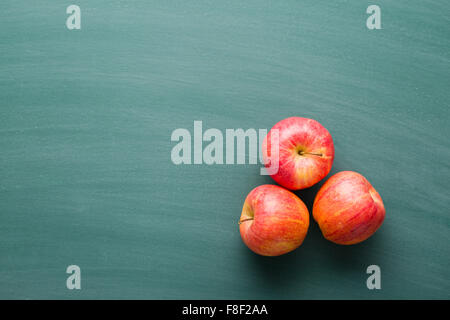 rote Äpfel an grüne Tafel Stockfoto