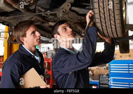 Mechaniker und Auszubildenden arbeiten unter dem Auto Stockfoto