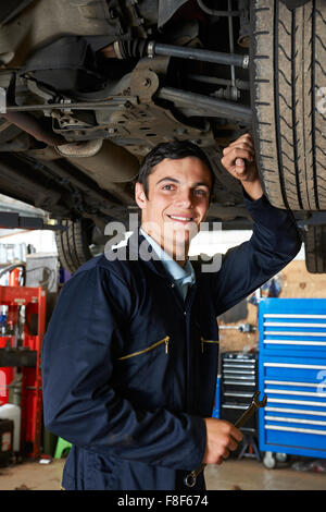 Auszubildende Mechaniker arbeiten unter dem Auto Stockfoto