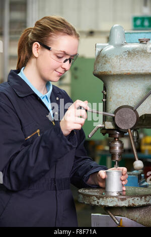 Weiblichen Lehrling Ingenieur mit Bohrer In Fabrik Stockfoto