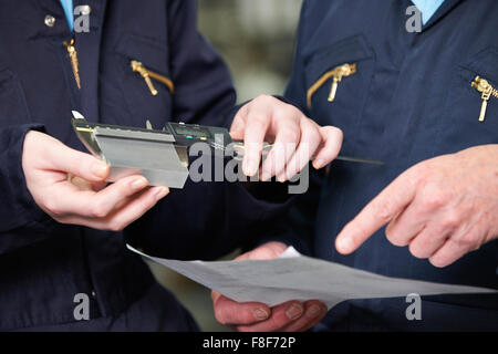 Nahaufnahme von Ingenieuren Komponente mit Mikrometer messen Stockfoto