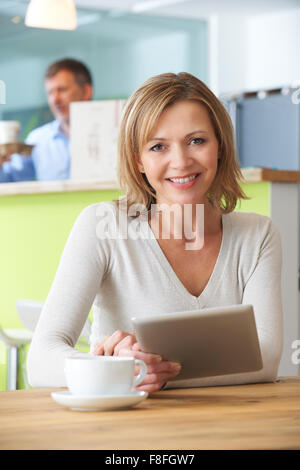 Woman Looking At Digital-Tablette im Cafe Stockfoto