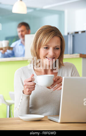 Frau mit Laptop im Café Stockfoto