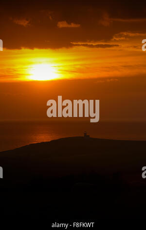 Ein Sonnenuntergang über Belle Tout Leuchtturm in der Nähe von Beachy Head auf der South Downs in Sussex, Großbritannien Stockfoto