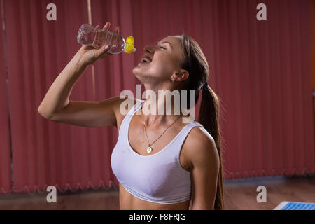 Eine halbe Stelle erschossen eine glückliche gesunde Frau Wasser in einer Flasche mit Augen geschlossen. Stockfoto