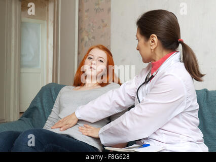 Reife Arzt berührt Bauch des Jugendlichen Patienten im Innenraum Stockfoto