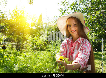 Kaukasische Frau untersuchen Pflanzen im Garten Stockfoto