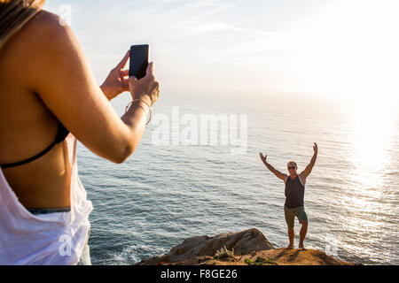 Kaukasischen Mann Fotografieren Freundin auf Felsen Stockfoto