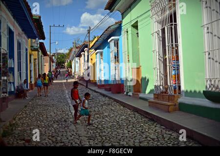 Kinder spielen auf einer gepflasterten Straße, gesäumt von bunten Häusern in Trinidad Provinz Sancti Spiritus-Kuba Stockfoto