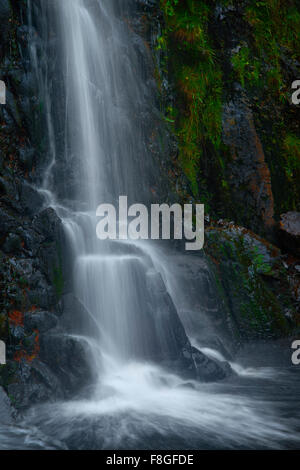 Wasserfall fließt über Felswand Stockfoto