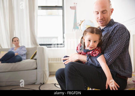 Vater und Tochter sitzen auf Bett Stockfoto