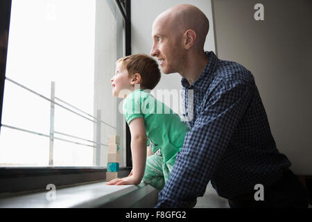 Vater und Sohn suchen Fenster Stockfoto