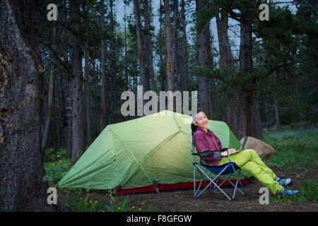Japanische Frau mit Laptop am Campingplatz Stockfoto
