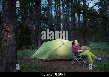 Japanische Frau mit Laptop am Campingplatz Stockfoto