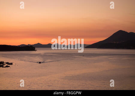Kleines Boot und Sonnenuntergang an der kroatischen Küste Stockfoto