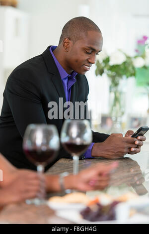 Mann mit Handy an Weinbar Stockfoto