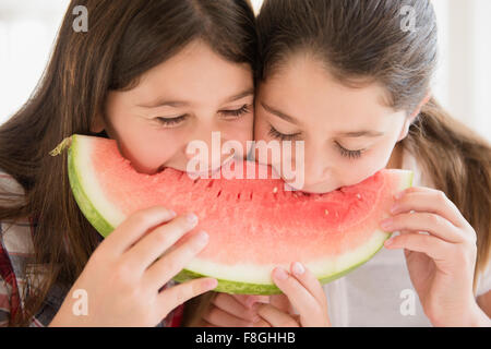 Kaukasische Zwillingsschwestern Wassermelone essen Stockfoto