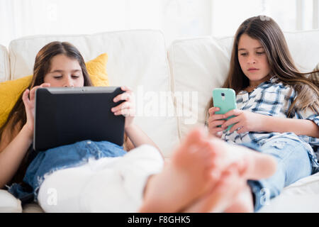 Kaukasische Zwillingsschwestern-Technologie Stockfoto