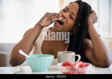 Schwarze Frau Gähnen am Tisch Stockfoto