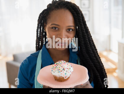 Schwarze Frau mit Kuchen auf Teller Stockfoto