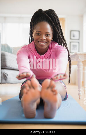 Schwarze Frau praktizieren Yoga im Wohnzimmer Stockfoto