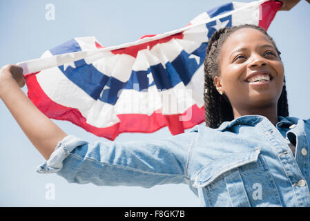 Schwarze Frau, die die amerikanische Flagge banner Stockfoto