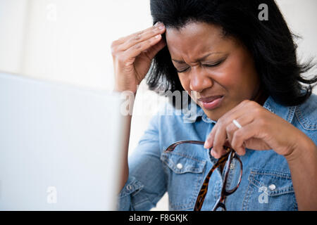 Frustrierte schwarze Frau reibt ihre Stirn Stockfoto