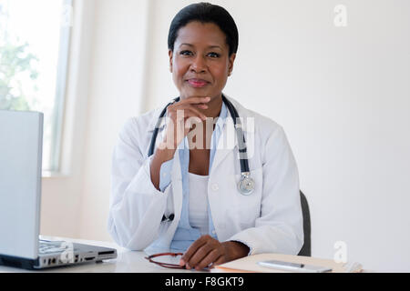 Schwarzen Doktor am Schreibtisch Stockfoto