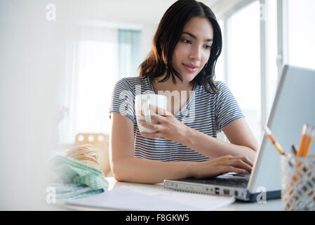 Hispanic Frau mit Laptop am Schreibtisch Stockfoto