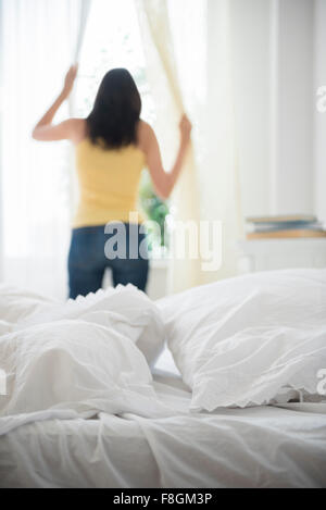 Hispanic Frau Eröffnung Vorhänge Stockfoto