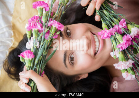 Hispanic Frau halten Blumen Stockfoto