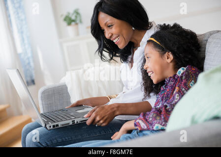 Mutter und Tochter mit Laptop auf sofa Stockfoto
