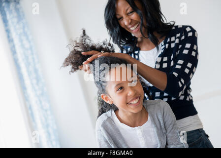 Mutter Styling Haar Tochter Stockfoto