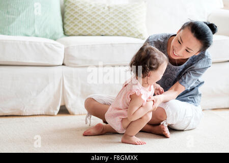 Mutter und Baby Tochter spielen im Wohnzimmer Stockfoto