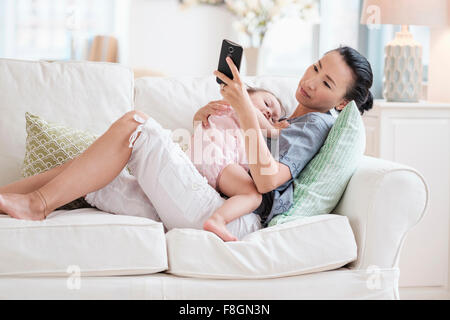 Mutter und Baby Tochter mit Handy Stockfoto